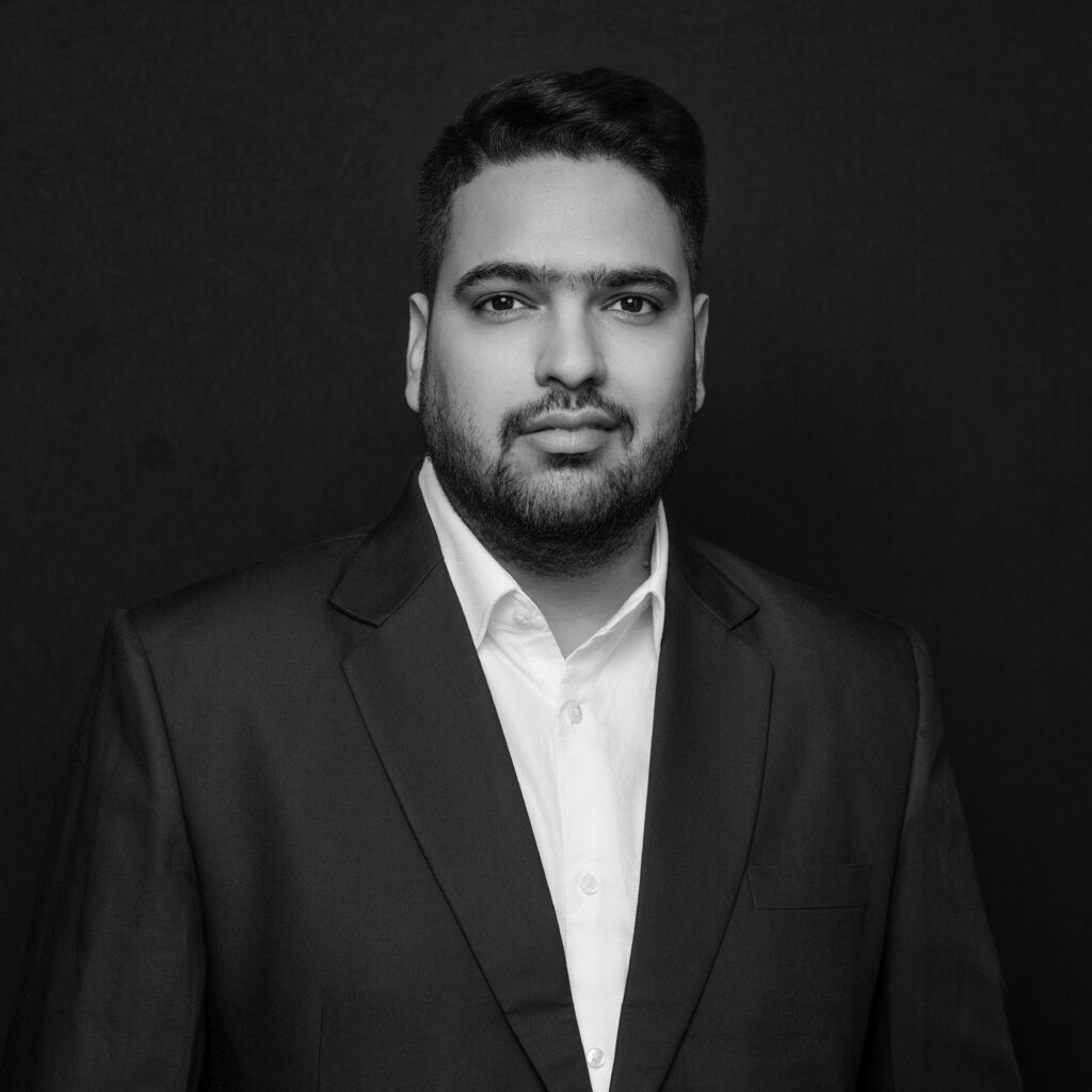A man with short hair and a beard wearing a dark suit jacket and white shirt poses in front of a plain dark background. Unified LLP | Toronto T. 416.787.7678 | Kitchener T. 519.729.5038 | Calgary T. 403-906-2351 | unifiedllp.com